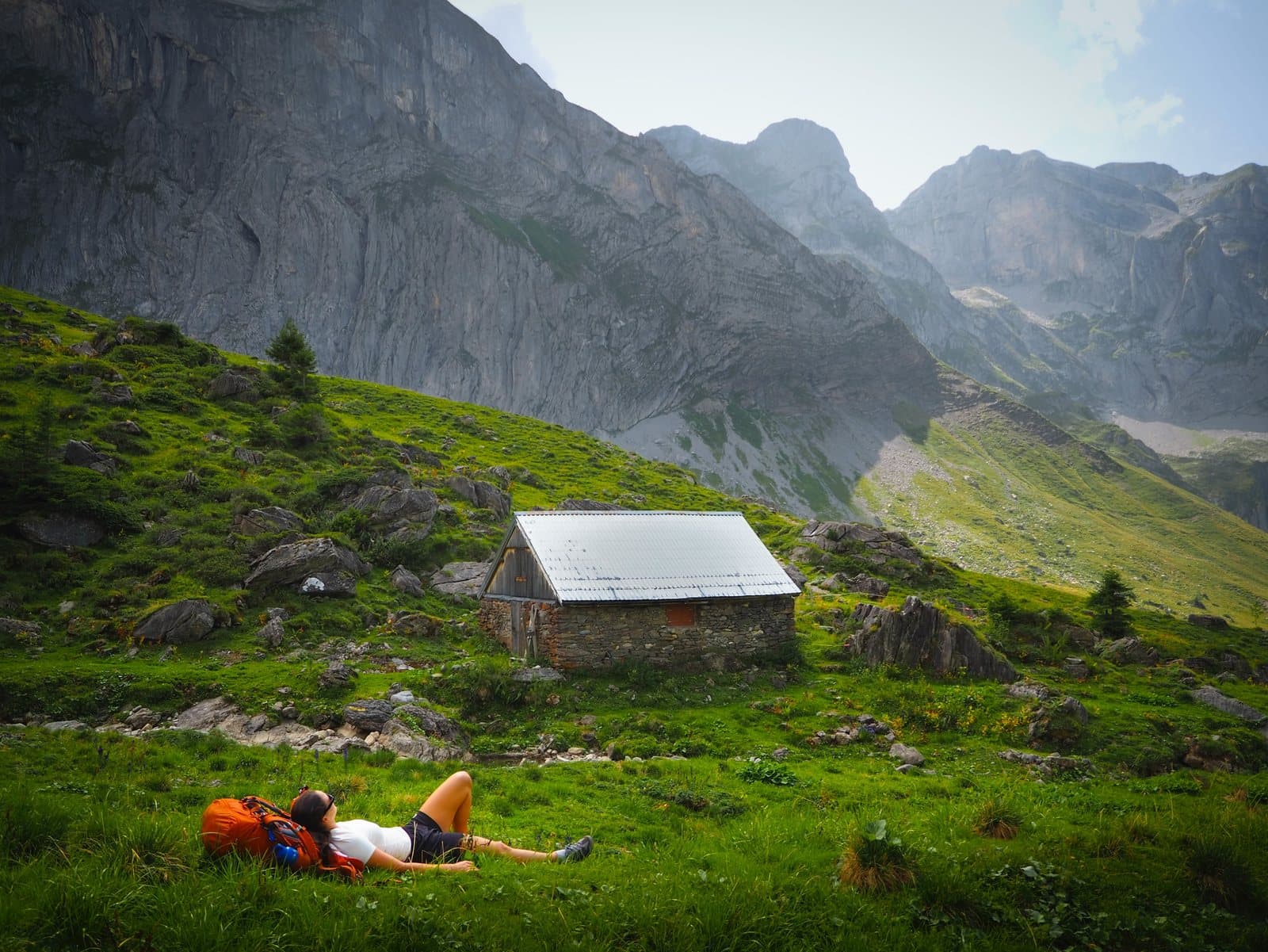 Pause im Gras vor einer Berghütte, beim Wildcampen